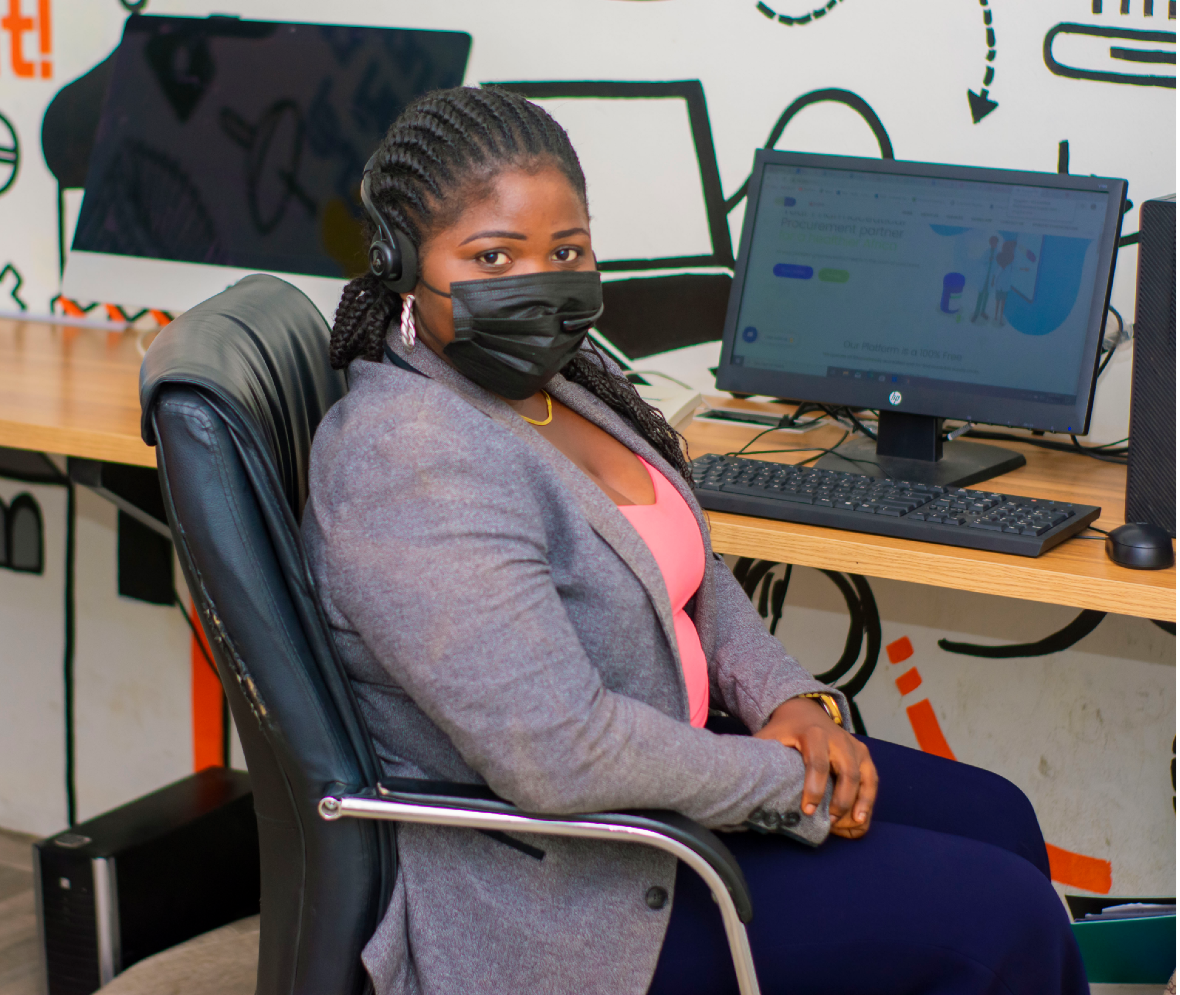 a contact support person at her office at DrugStoc wearing a black nose mask